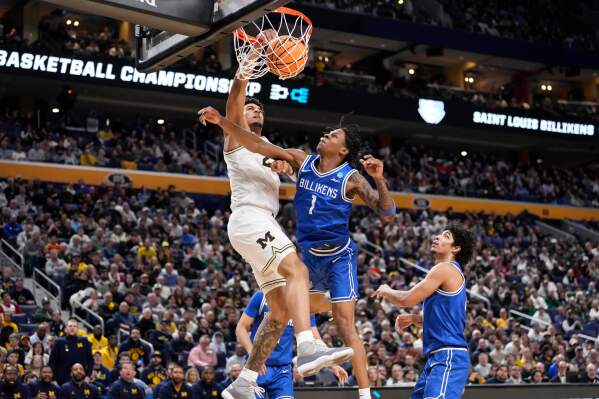 Michigan forward Yaxel Lendeborg (23) dunks over Saint Louis guard Quentin Jones (1) during the second half in the second round of the NCAA college basketball tournament, Saturday, March 21, 2026, in Buffalo, N.Y. (AP Photo/Yuki Iwamura)