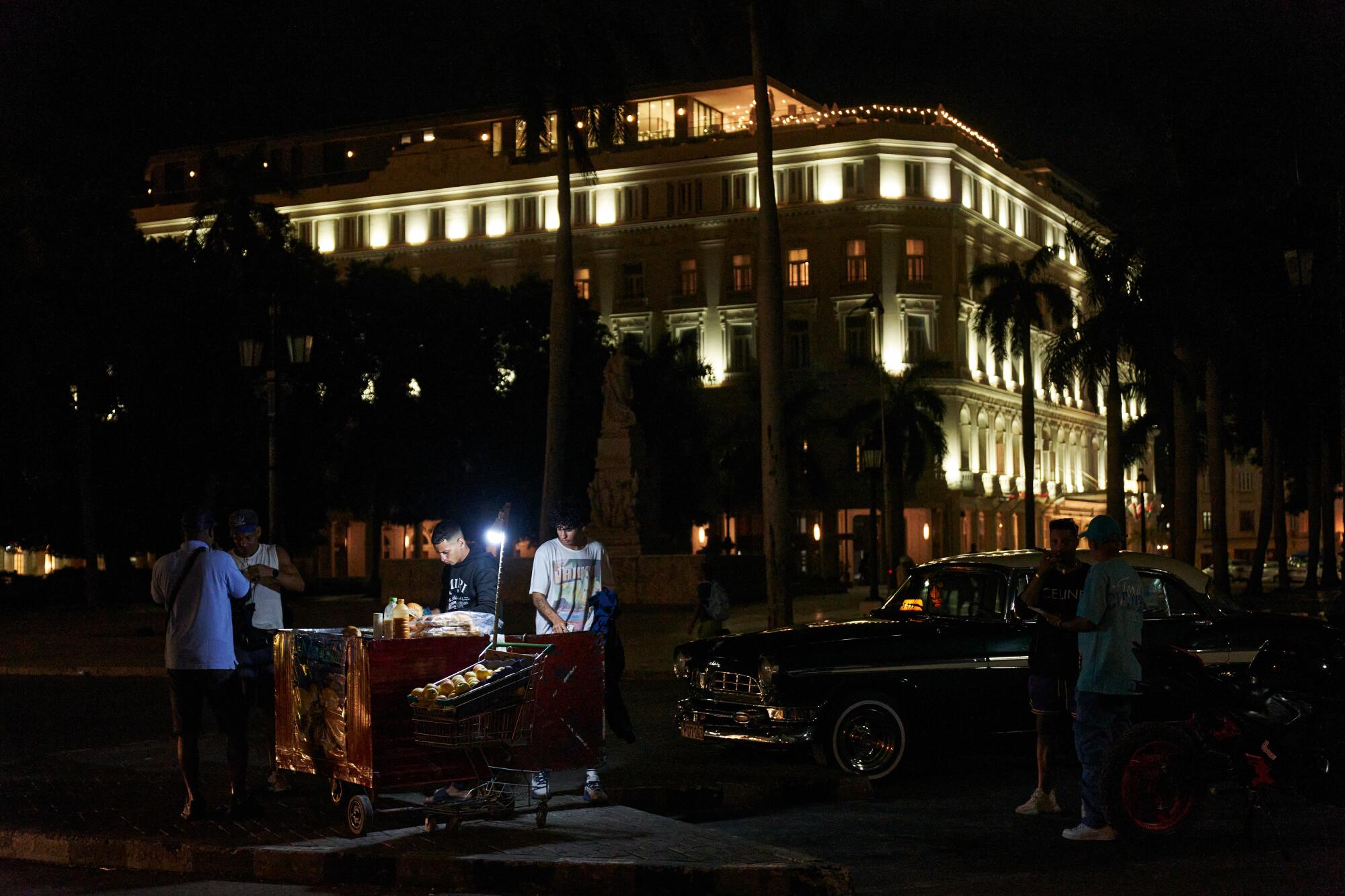 A food cart on a street at night.