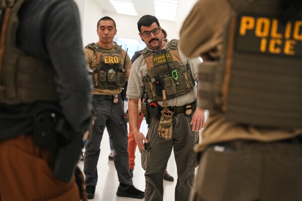 Federal immigration agents are seen at Newark Liberty International Airport, Monday, March 23, 2026, in Newark, N.J. (AP Photo/Angelina Katsanis)