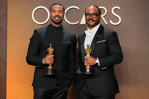 Michael B. Jordan, left, winner of the award for actor in a leading role for "Sinners," and Ryan Coogler, winner of the award for writing (original screenplay) for "Sinners," pose in the press room at the Oscars on Sunday, March 15, 2026, at the Dolby Theatre in Los Angeles. (Photo by Jordan Strauss/Invision/AP)