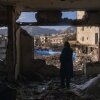 A woman looks out from her destroyed apartment in the remains of a residential and commercial building in the Shahrak-e Gharb neighborhood of Tehran, Iran, on March 21. The building was hit on March 16 amid U.S. and Israeli attacks and resulted in several deaths.