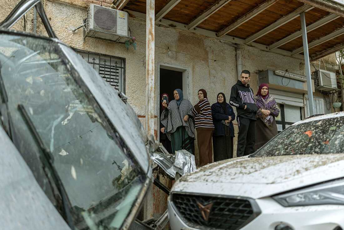 Arab-Israeli residents survey the damage following a projectile strike in the Arab-Israeli city of Kfar Qasim on Thursday.