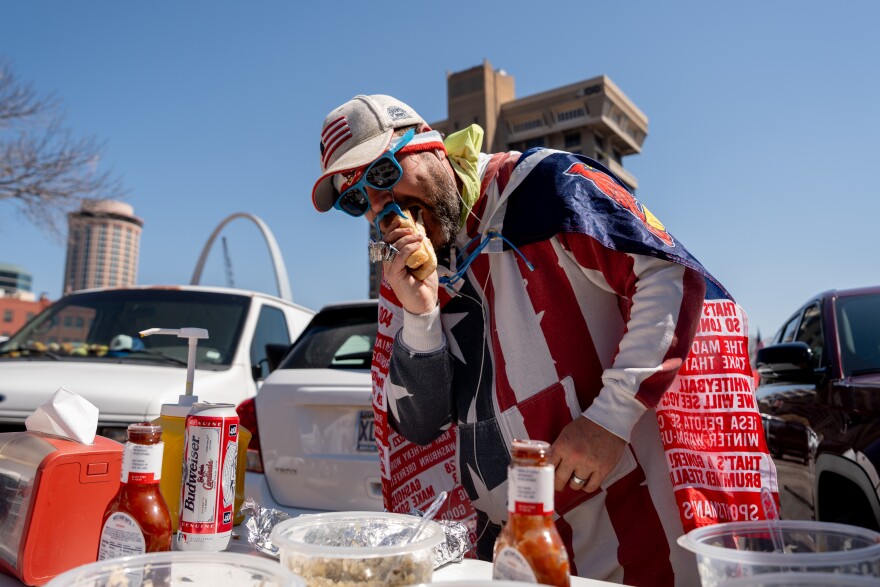 Trevor McCullough, of St. Ann, scarfs down a hotdog before the St. Louis Cardinals take on the Tampa Bay Rays for MLB Opening Day on Thursday, March 26, 2026, in downtown St. Louis.