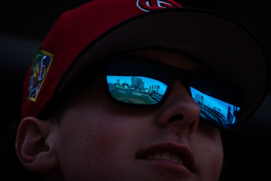 A St. Louis Cardinals fans looks towards the Gateway Arch as the team takes on the Tampa Bay Rays during MLB Opening Day on Thursday, March 26, 2026, in downtown St. Louis.