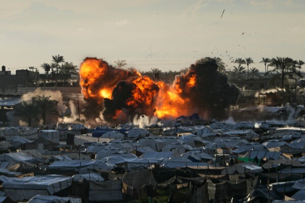 Smoke and flames rise from an Israeli military strike on a target next to a tent camp in Deir al-Balah, central Gaza Strip, Wednesday, March, 25, 2026. (AP Photo/Abdel Kareem Hana)