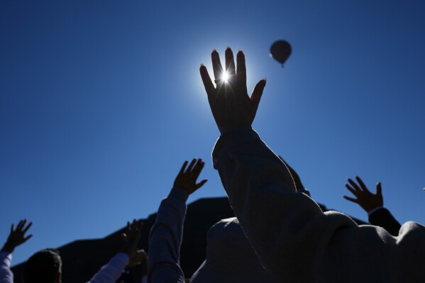 Visitors raise their hands as the sun rises above the Pyramid of the Sun, as part of the Spring equinox celebrations in Teotihuacan, Mexico, Saturday, March 21, 2026. (AP Photo/Marco Ugarte)