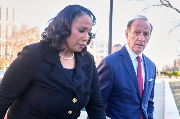 Federal Reserve governor Lisa Cook and attorney Abbe Lowell, arrive at the Supreme Court in Washington, Wednesday, Jan. 21, 2026. (AP Photo/Mark Schiefelbein)