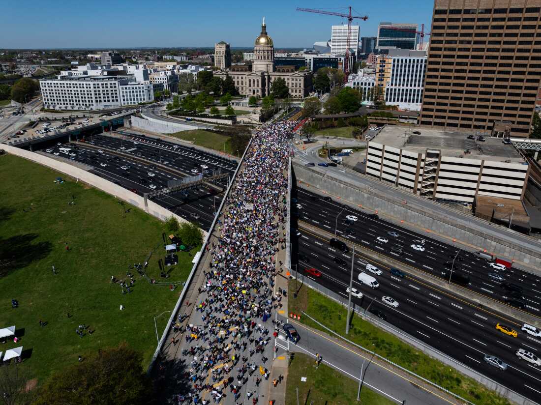 An aerial view shows people marching near the Georgia state Capitol building during the "No Kings" national day of protest in Atlanta, Georgia, on March 28, 2026. Nationwide protests against US President Donald Trump are expected Saturday as millions of people vent fury over what they see as his authoritarian bent and other forms of cruel, law-trampling governance. It is the third time in less than a year that Americans will take to the streets as part of a grassroots movement called "No Kings," the most vocal and visual conduit for opposition to Trump since he began his second term in January 2025. (Photo by Elijah Nouvelage / AFP via Getty Images)