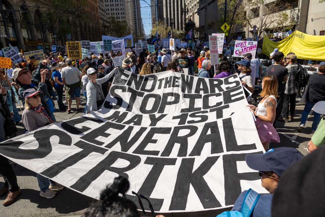 Protesters hold a banner reading “End the wars, stop ICE, general strike” during a rally at Embarcadero Plaza on March 28, 2026, in San Francisco.