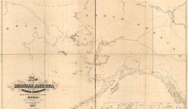 Workers check solar panels installed over a lake from underneath while in a boat.