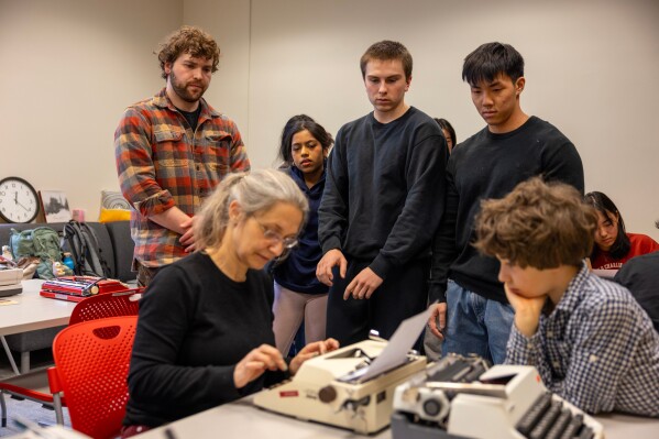 Grit Matthias Phelps gives students a demonstration on how to use a typewriter before class at Cornell University, Friday, March 20, 2026, in Ithaca, N.Y. (AP Photo/Lauren Petracca)