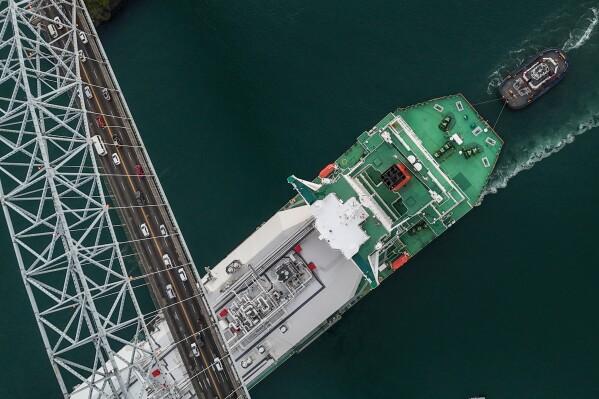 A liquefied natural gas carrier sails under Las Americas Bridge through the Panama Canal in Panama City, Tuesday, March 24, 2026. (AP Photo/Matias Delacroix)