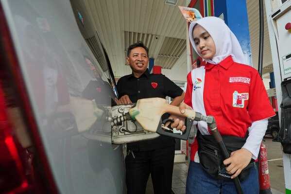 An employee fills fuel in a car at a gas station in Jakarta, Indonesia, Tuesday, March 3, 2026. (AP Photo/Achmad Ibrahim)