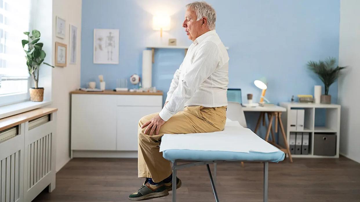 Worried senior Caucasian man, an patient, sitting on examination table at the examination medical room
He is waiting for medical test results, worrying about them