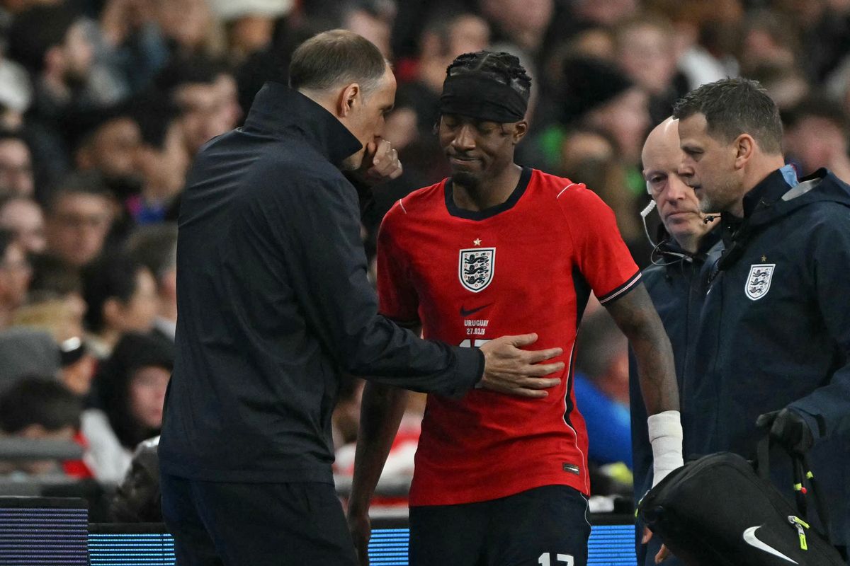 England's German head coach Thomas Tuchel (L) consoles England's midfielder Noni Madueke (C) as he leaves the game, injured during the friendly International football match between England and Uruguay