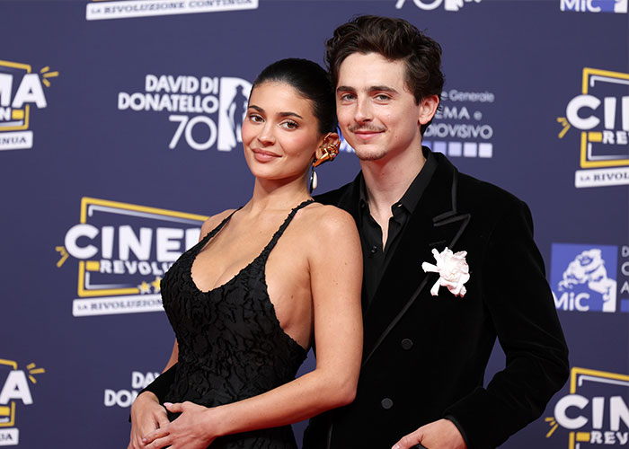 Timothée Chalamet and female companion at a film event, highlighting academy insider claims about his Oscar chances.