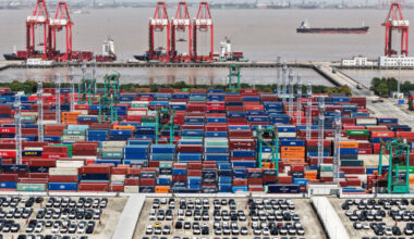 FILE PHOTO: Drone view shows electric vehicles (EV) for export and containers sitting at a port in Shanghai