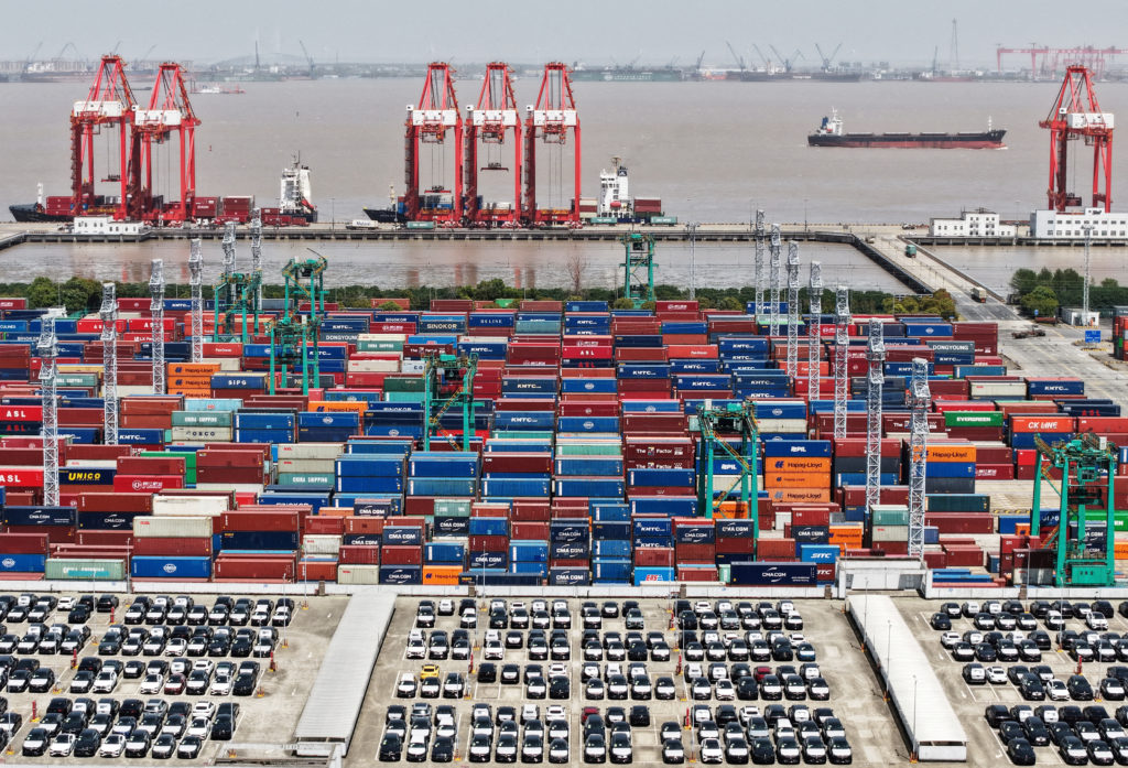 FILE PHOTO: Drone view shows electric vehicles (EV) for export and containers sitting at a port in Shanghai