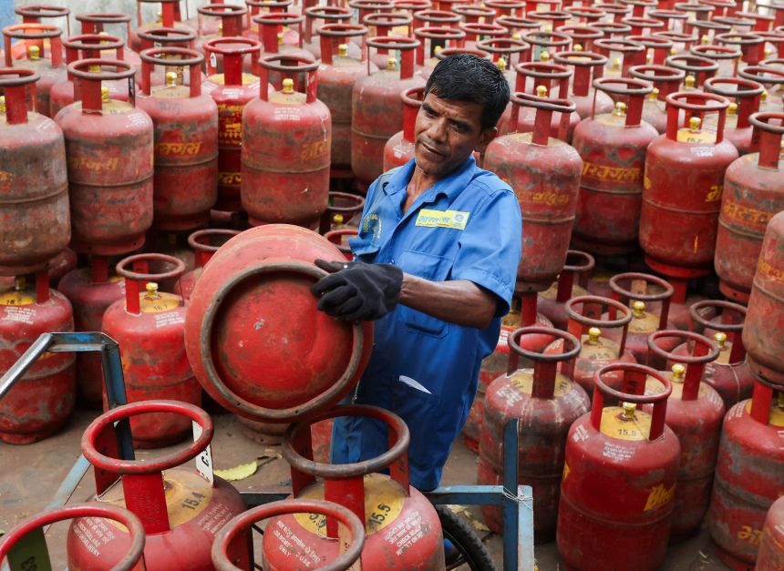 A man loads LPG cylinders onto a cart at a warehouse amid supply disruptions following the U.S.-Israeli conflict with Iran, in Mumbai, India, on March 11, 2026.