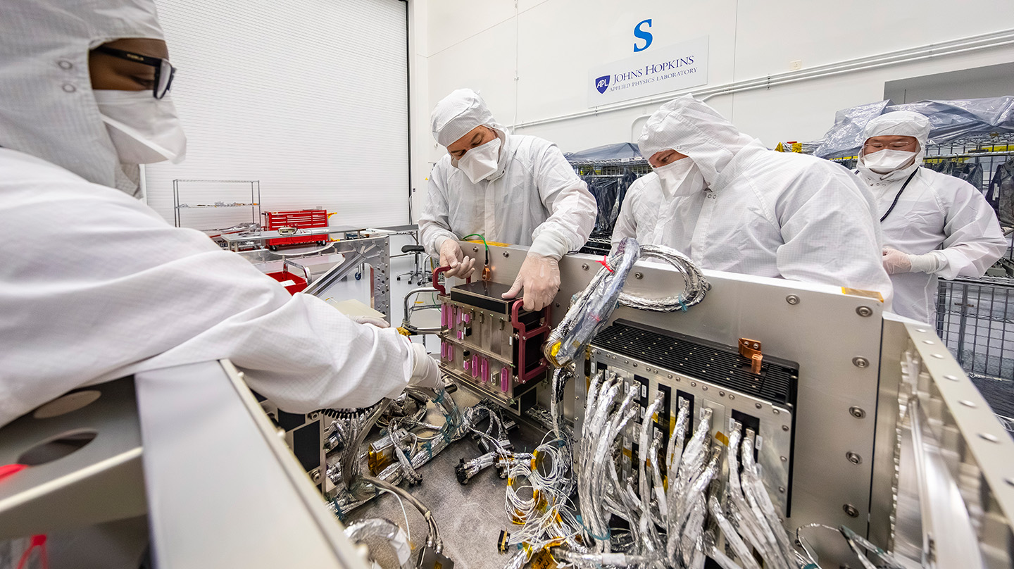 From left, Carlisa Drew, Seth Harvey, Anthony Fanelli, Emory Toomey and TJ Lee conduct power and functional testing on Dragonfly’s Integrated Electronics Module (IEM) and Power Switching Unit (PSU) in the cleanroom at Johns Hopkins APL