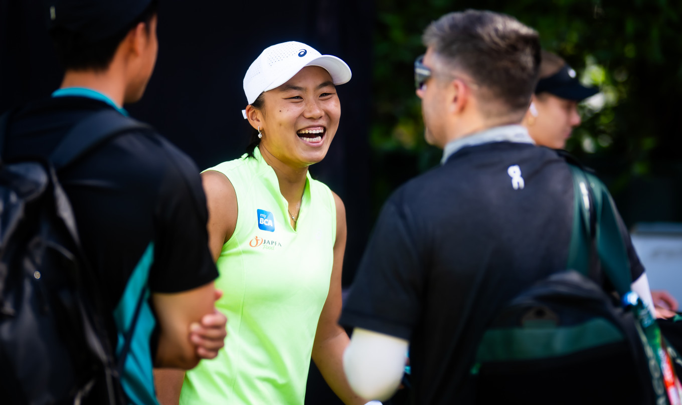Janice Tjen laughs with her coaches on the sidelines of the Dubai Duty Free Tennis Championships in Dubai, United Arab Emirates, on Feb. 18, 2026.