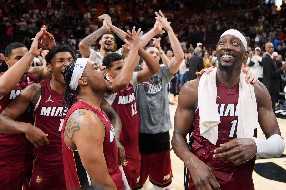Miami Heat center Bam Adebayo, right, celebrates with teammates after he scored 83 points, the ...