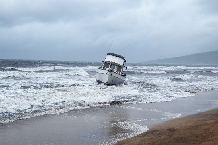 A boat is grounded on a beach by the shore