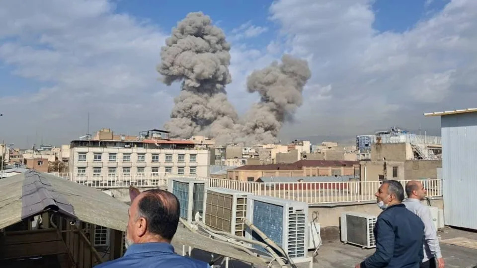 People watch as smoke rises on the skyline after an explosion in Tehran, Iran, on February 28. - AP