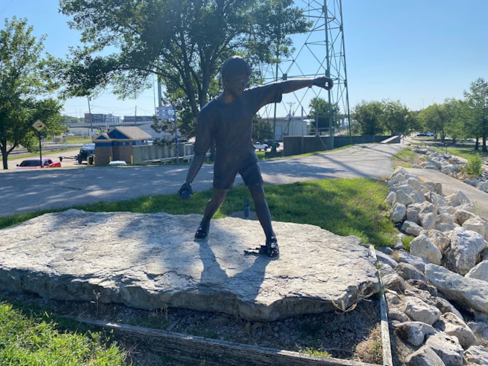 A bronze statue at Leach Park in Bettendorf shows a boy getting ready to skip a rock on the...