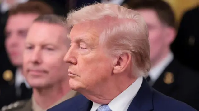 A photo of Trump speaking in front of US military personnel