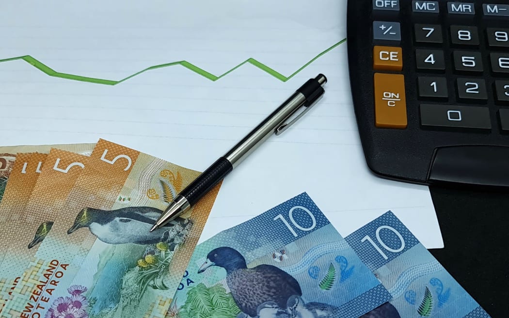 New Zealand banknotes, pen and calculator on background with rising trend green line. Money finance economy