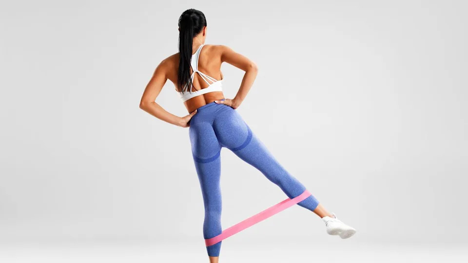  A photo of a woman doing a resistance band glute exercise . 