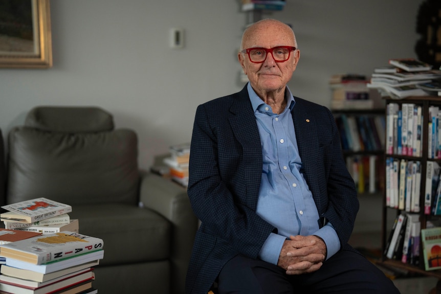 Professor Allan Fels sits in a home library filled with books.