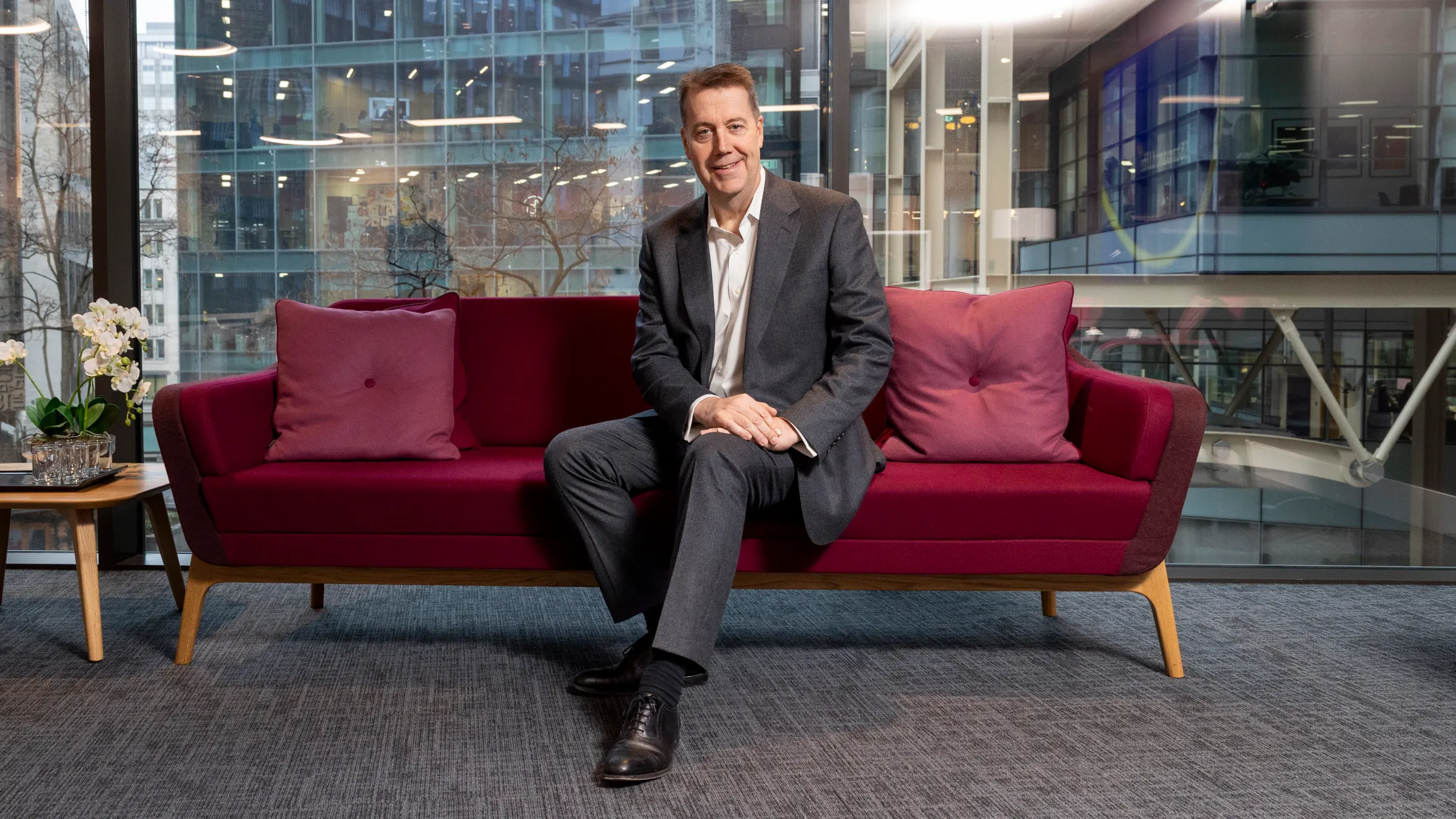 Andy Briggs, CEO of Phoenix, seated on a red couch in his office at Twenty Old Bailey.