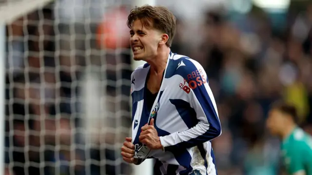 West Brom's Isaac Price pulls down the collar of his shirt in celebration