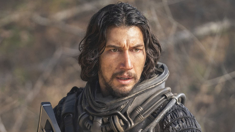 Mills (Adam Driver) stands warmly outside in 65