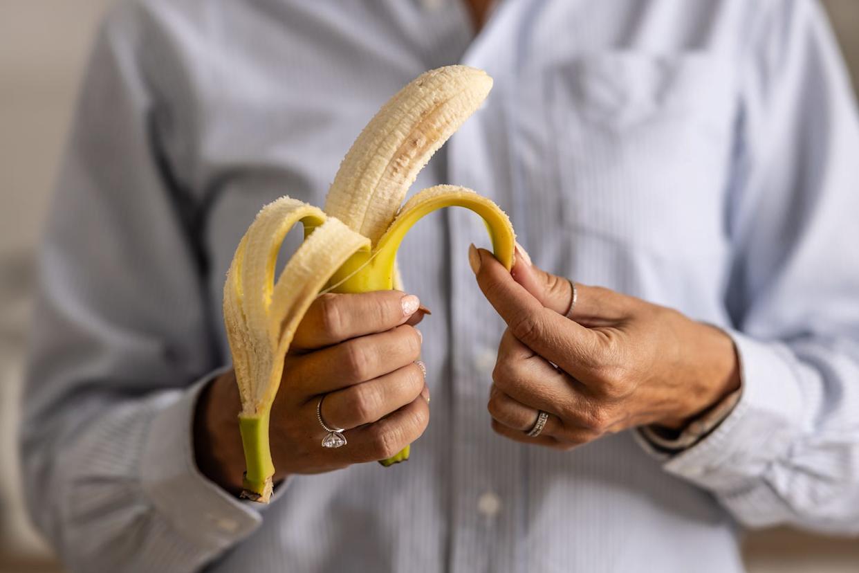 close up of a woman's hands peeling a banana