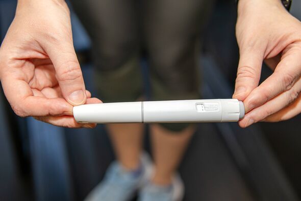 Woman holding injection pen for weight loss treatment, close-up. Concept of obesity therapy, diabetes medication and modern heal