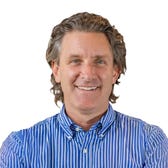 Alistair Barr, global tech editor of Business Insider, smiles at the camera while wearing a blue and white striped shirt.