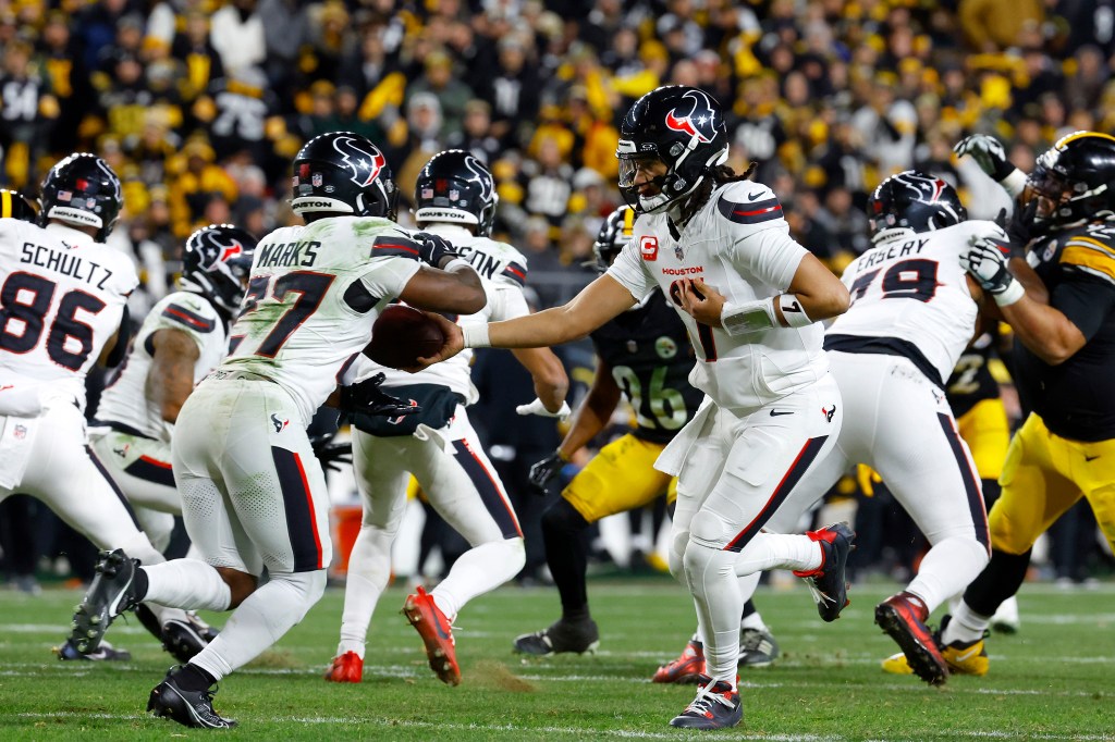 C.J. Stroud #7 of the Houston Texans hands off to Woody Marks #27 of the Houston Texans.