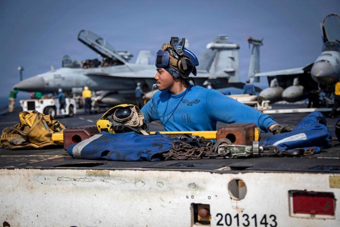 A US Navy Aviation soldier operates a tractor on the flight deck of the aircraft carrier USS Abraham Lincoln, in the Arabian Sea, in this handout photograph taken on February 20, 2026, and released by the US Navy on February 24, 2026.
