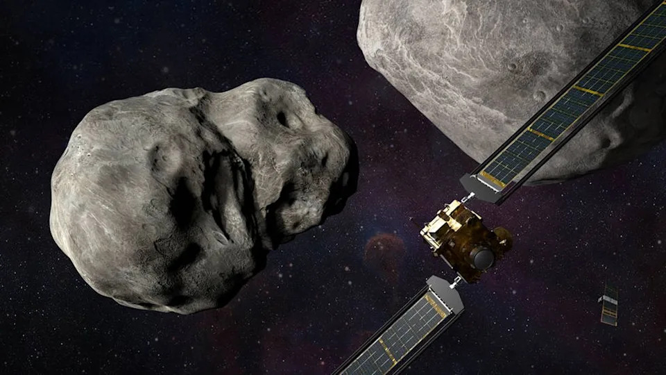  A box-shaped spacecraft with solar wings approaching two space rocks. 
