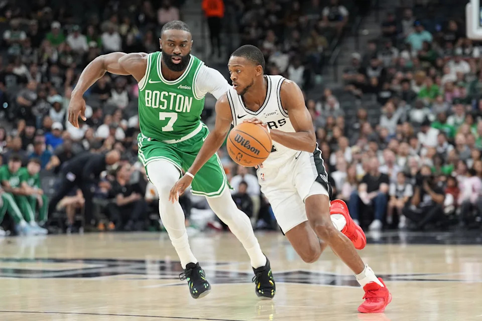 Mar 10, 2026; San Antonio, Texas, USA; San Antonio Spurs guard De'aaron Fox (4) dribbles the ball against Boston Celtics guard Jaylen Brown (7) in the first half at Frost Bank Center. Mandatory Credit: Daniel Dunn-Imagn Images