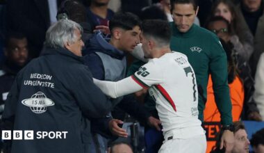 Chelsea's Pedro Neto embraces a PSG ball boy in the aftermath of shoving him during their Champions League match