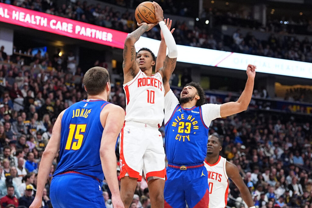 Houston Rockets forward Jabari Smith Jr. (10) goes up for a basket between Denver Nuggets center Nikola Jokić  (15) and forward Cameron Johnson (23) in the second half of an NBA basketball game Wednesday.