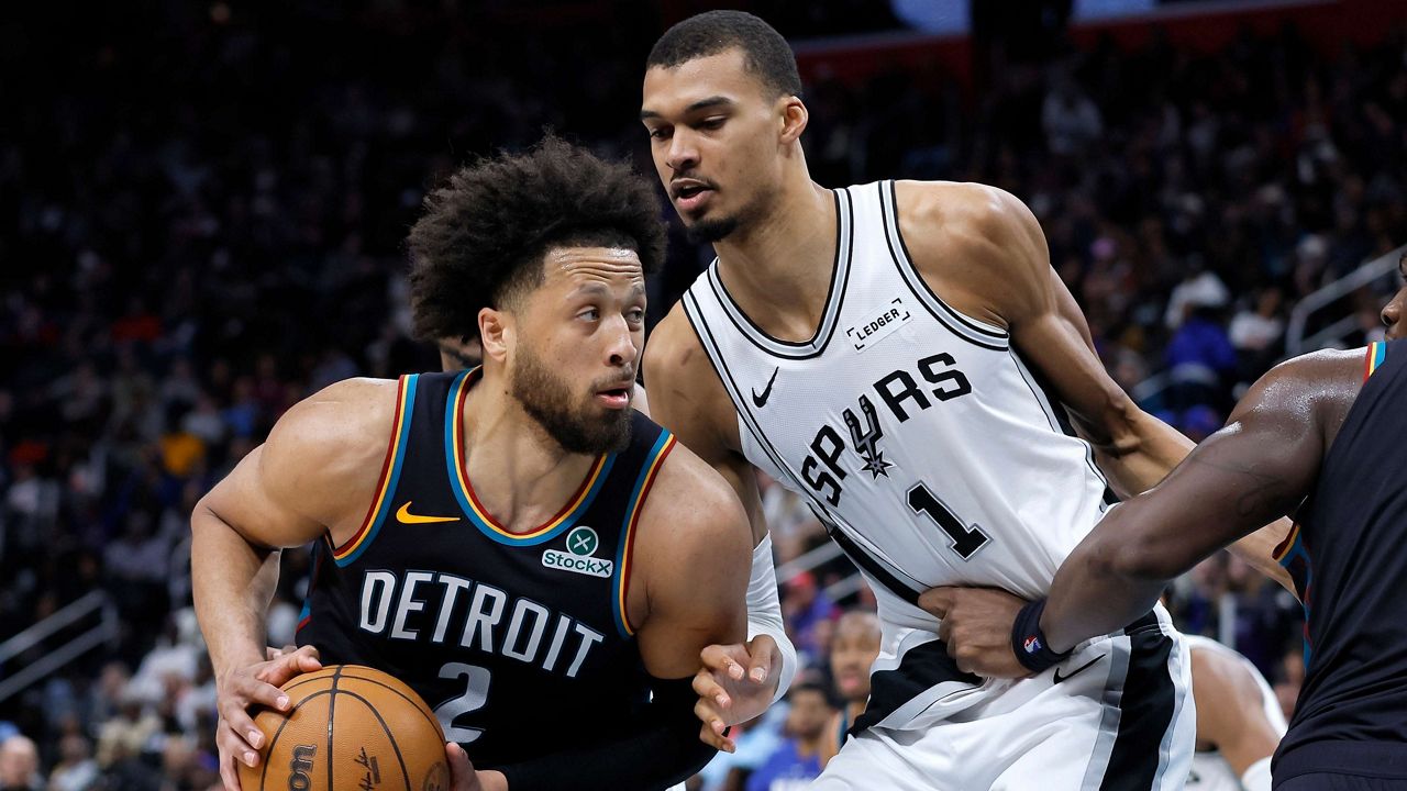 Detroit Pistons guard Cade Cunningham (2) drives against San Antonio Spurs forward Victor Wembanyama (1) during the second half of an NBA basketball game Monday, Feb. 23, 2026, in Detroit. (AP Photo/Duane Burleson)