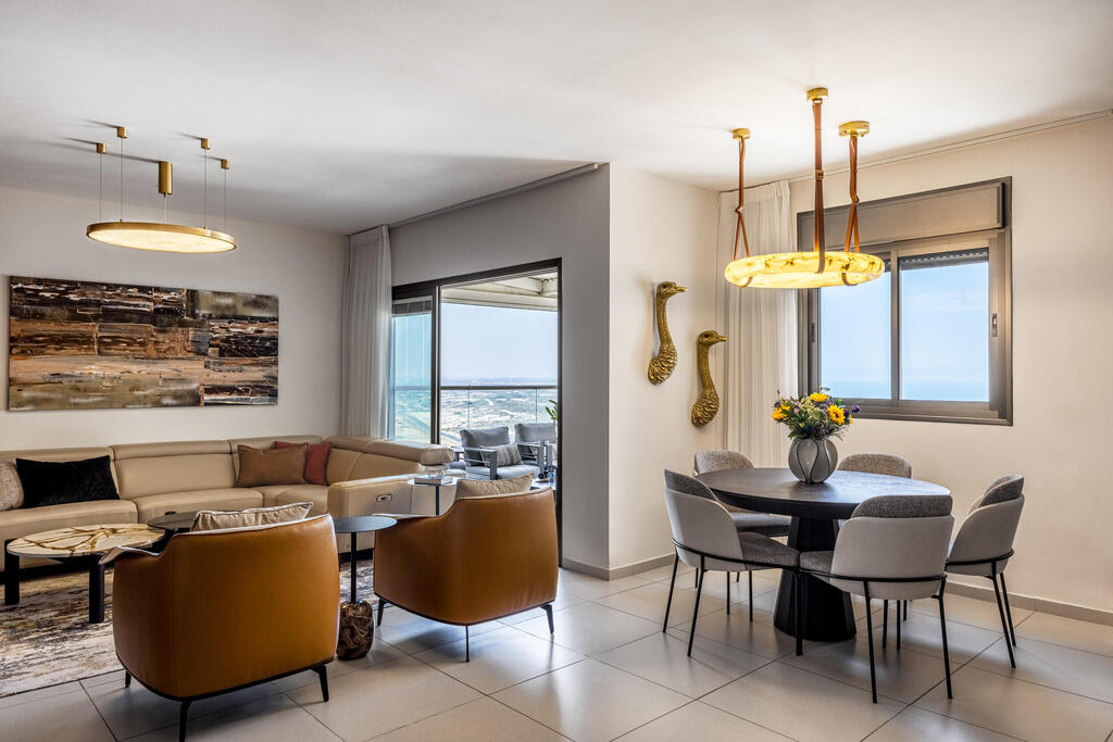 The dining area beside the living room, featuring ostrich sculptures (Photo: Yonatan Tamir) דירה לשוטר רווק, עיצוב: דותן ויסמין כהן
