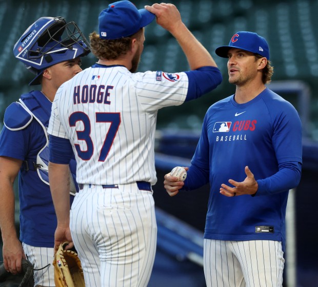Chicago Cubs pitching coach Tommy Hottovy (right) talks with catcher Reese McGuire and relief pitcher Porter Hodge (37) at the end of a team workout at Wrigley Field in Chicago on Tuesday, Oct. 7, 2025, ahead of Wednesday's Game 3 of the NL Division Series against the Milwaukee Brewers. (Chris Sweda/Chicago Tribune)