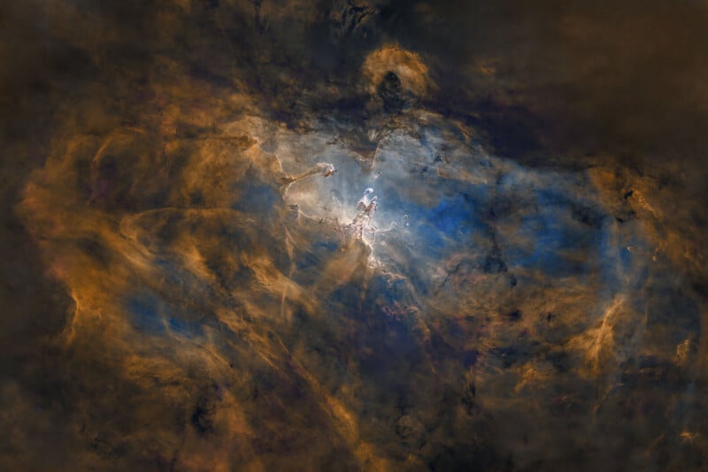 Swirling clouds of dark orange, brown, blue, and white gases form a dramatic nebula in space, illuminated by bright light at the center, creating a dynamic, colorful cosmic scene.