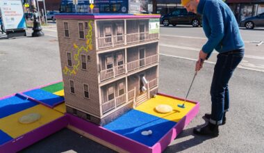 CultureHouse Executive Director Aaron Greiner took a swing at a new mini golf hole his nonprofit recently placed in Somerville's Union Square.